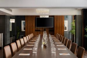 a long table in a room with chairs and a tv at The Athenaeum Hotel & Residences in London