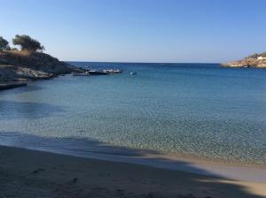 a beach with a body of water with a boat in it at Beachfront Majestic Villa in Liaropá