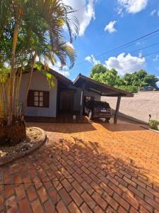 a house with a palm tree and a driveway at Suíte até 3 pessoas, Centro, Piscina in Foz do Iguaçu