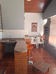 a kitchen with a sink and a table and a fireplace at Suíte até 3 pessoas, Centro, Piscina in Foz do Iguaçu
