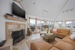 a living room with a fireplace and a flat screen tv at 1067 - Easy Street in Corolla