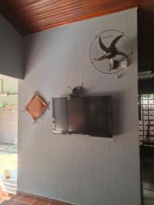 a wall with a flat screen tv and a fan at Suíte até 3 pessoas, Centro, Piscina in Foz do Iguaçu +1 photo
