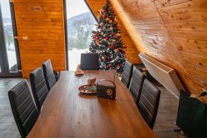 a dining room with a christmas tree and a table at Cabana Z-Haven in Ungureni +12 photos