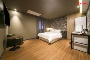 a bedroom with a bed and a desk with a television at 월호텔 in Cheonan