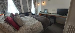 a bedroom with a bed and a desk and a television at Cranborne Guest Accommodation Exclusively for Adults in Torquay