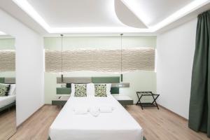 a bedroom with a large white bed and a chandelier at Giulio Cesare Luxury Rooms in Rome