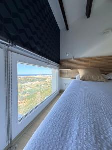 a bedroom with a bed and a large window at Mediterranean View Apartment in Denia