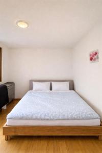 a bedroom with a large bed with white walls at Lake View near Lucerne in Hergiswil