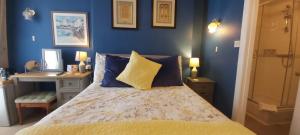 a bedroom with a bed with blue walls at Cranborne Guest Accommodation Exclusively for Adults in Torquay