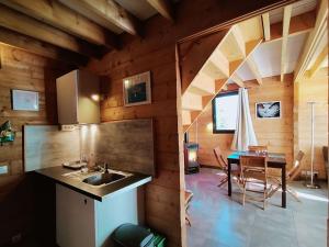 a kitchen and dining room in a wooden house at Aux Gîtes d'Orient in Géraudot