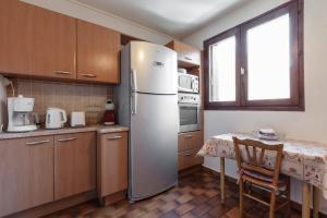 a kitchen with a refrigerator and a table and a window at T3 avec terrasse plein sud au pied des télécabines in Briançon