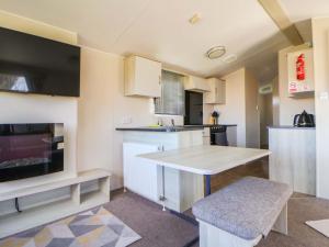 a small kitchen with a table and a tv at Dunes View in Prestatyn