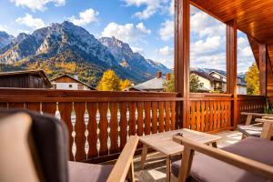 ein Balkon mit Tisch und Stühlen und Bergen in der Unterkunft The Bear Chalet with Private Hot Tub in Buşteni