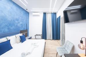 a bedroom with a white bed and a blue wall at Giulio Cesare Luxury Rooms in Rome