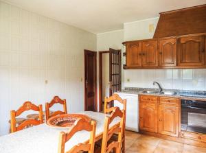 a kitchen with wooden cabinets and a table and chairs at Casa do Batoco in Vieira do Minho