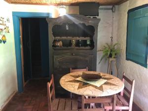 a table and chairs in a room with a fireplace at Pousada Recanto dos Chalés - Itambé do Mato Dentro in Itambé do Mato Dentro