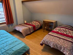 a room with three beds and a table in it at F ou d'Lac in Doussard
