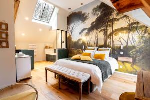 a bedroom with a large bed with a painting on the wall at Les Granges de Juvardeil in Juvardeil +42 photos