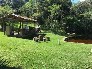 a person sitting under a gazebo in a park at Pousada Recanto dos Chalés - Itambé do Mato Dentro in Itambé do Mato Dentro