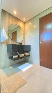 a bathroom with a large mirror and a sink at Pousada Recanto dos Chalés - Itambé do Mato Dentro in Itambé do Mato Dentro