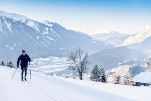 a man is skiing down a snow covered mountain at Ropferhof in Telfs-Buchen