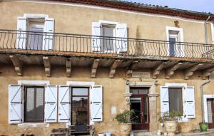 a building with white doors and windows and a balcony at La Terrasse in La Pervenche