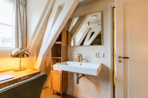 a bathroom with a sink and a desk and a mirror at Brass Hotel in Utrecht +68 photos