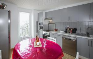 a kitchen with a table with a pink blanket on it at La Terrasse in La Pervenche