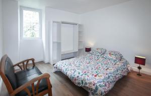 a bedroom with a bed and a chair and a window at La Terrasse in La Pervenche