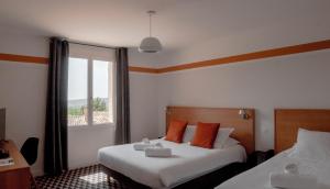 a hotel room with two beds and a window at La Maison des Ocres - Provence in Roussillon +172 photos