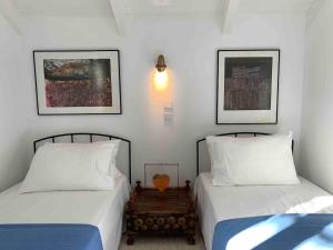 two beds sitting next to each other in a bedroom at Anassa Boutique Beach House in Sami