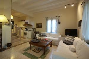 a living room with a white couch and a table at Anassa Boutique Beach House in Sami