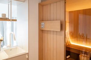 a bathroom with a wooden wall with a sink at Villa Astoria - Kühlungsborn in Kühlungsborn +129 photos