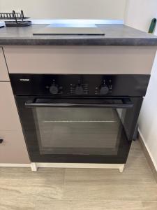 a black stove sitting under a counter in a kitchen at Best4You Apartment Therme Airport in Baloteşti