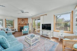 a living room with a blue couch and a tv at 3660 - Duckingham in Duck
