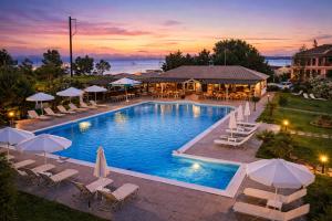 a pool with chairs and umbrellas at a resort at Egrypos Hotel in Petrití