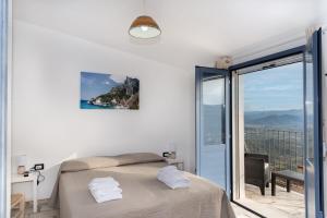 a white bedroom with a bed and a balcony at B&B Golgo in Baunei +22 photos