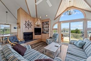 a living room with two couches and a fireplace at 3945 - Sea Lodge II in Duck