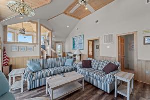 a living room with two couches and a table at 3945 - Sea Lodge II in Duck