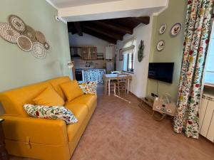 a living room with a yellow couch and a kitchen at La Corte di San Rocco in Murazzano