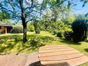 a wooden boardwalk in a yard with a tree at Le Petit Ousson Studio avec Jardin in Briare