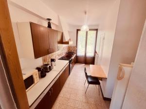 a kitchen with a counter and a table and a microwave at Le Petit Ousson Studio avec Jardin in Briare