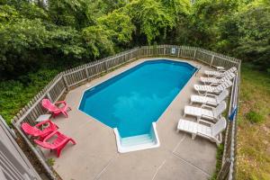 an overhead view of a swimming pool with lawn chairs and a group at 3944 - Carolina Escape in Duck