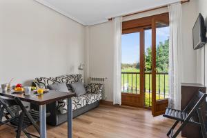 a living room with a couch and a table at Apartamentos Rurales & Spa Antilles Playa in Llanes