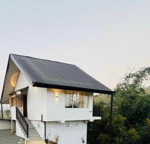 a small white house with a black roof at Moon Mist Villa in Kotagala