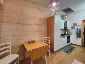 a dining room with a wooden table and a kitchen at Piccolo Appartamento Casa Vacanze B&B Angela in Clusone +27 photos