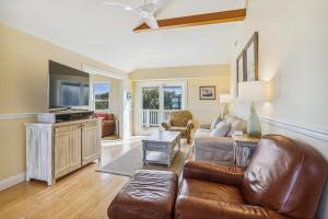 a living room with a couch and a tv at 3675 - Seaducktion in Duck