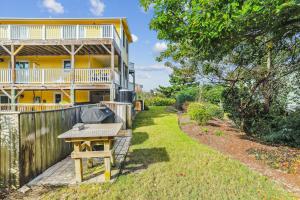 a backyard with a grill and a house at 3675 - Seaducktion in Duck