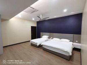 a bedroom with two beds and a ceiling fan at Sweetsweet homestay in Banting