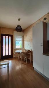 a kitchen and dining room with a table and a refrigerator at Piccolo Appartamento Casa Vacanze B&B Angela in Clusone